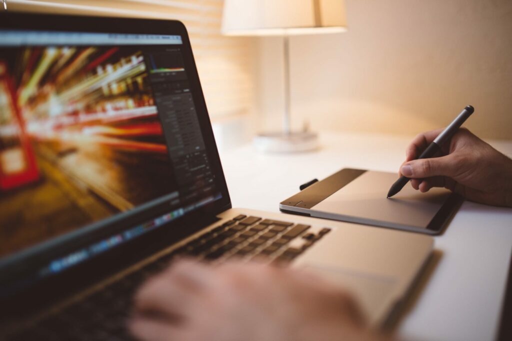 Computer mit Photoshop und eine Person die ein Bild bearbeitet
