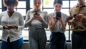 Vier verschiedene Mädchen mit Handy in der Hand