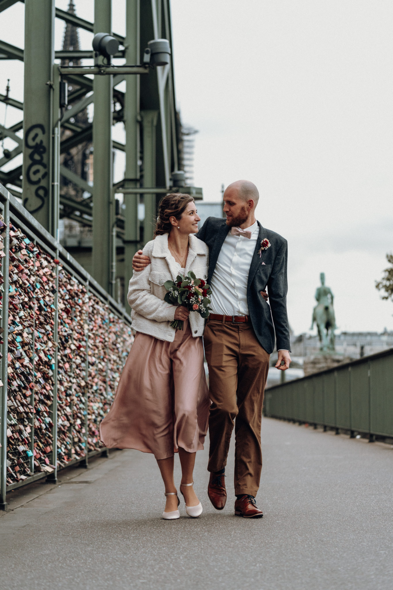 DSC00394 Glückliches Hochzeitspaar läuft während Hochzeitsshooting auf Hohenzollernbrücke