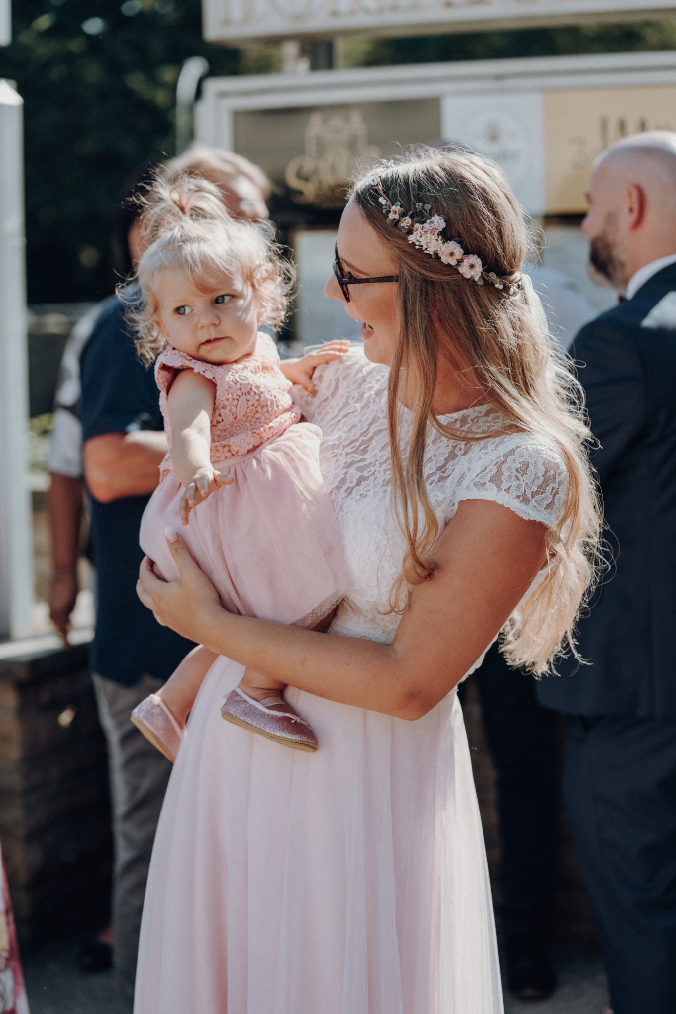 karte506245 Braut mit Baby auf dem Arm vor Standesamt