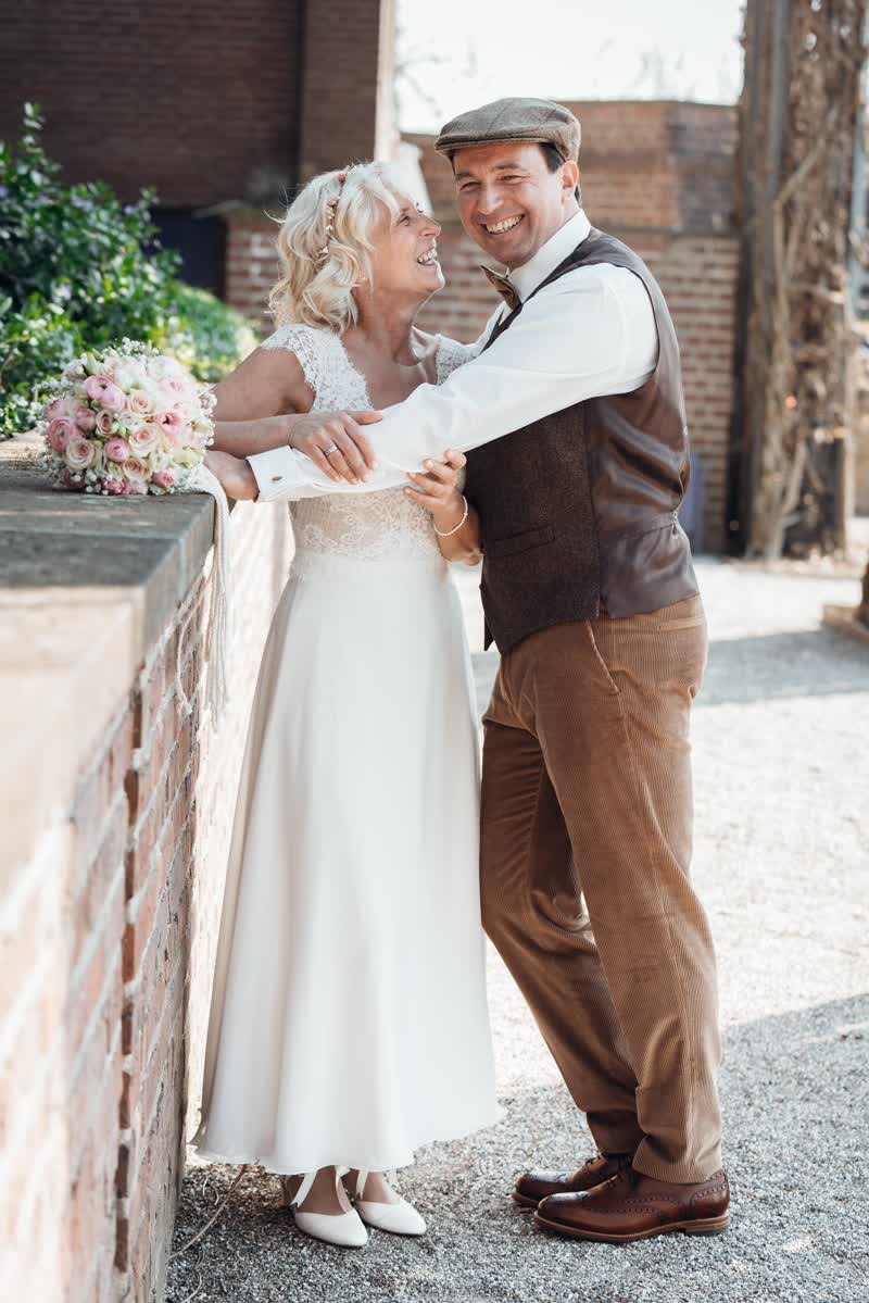 utilRequest-30.cgi Hochzeitspaar lehnt während Paarshooting glücklich an Mauer