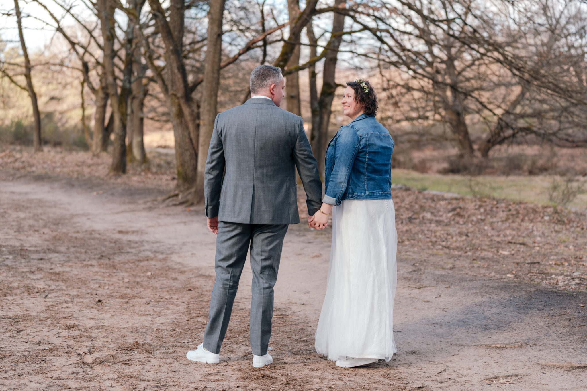 73R01902-2 Hochzeitspaar steht auf Weg im Wald