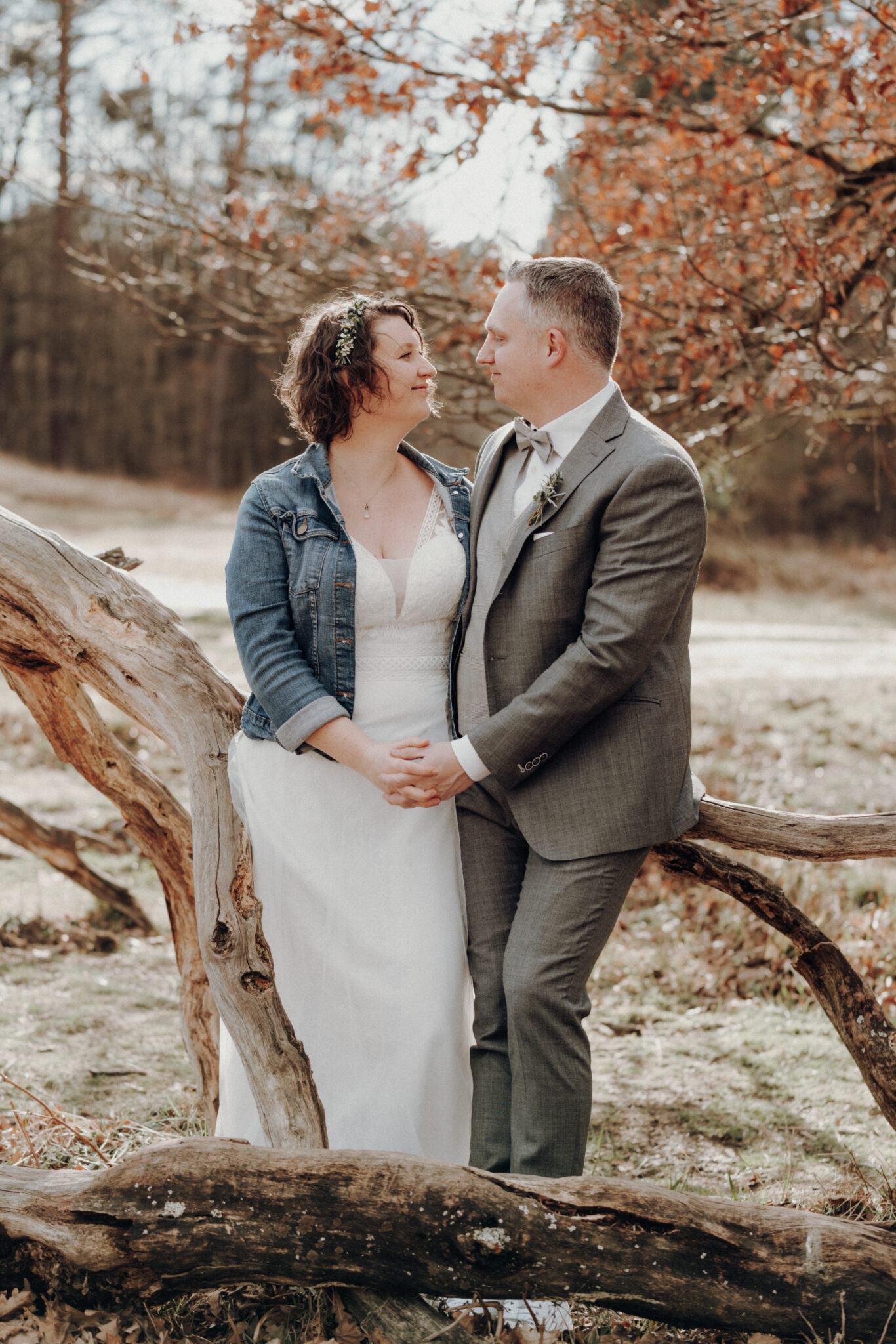 73R02130-2 Hochzeitspaar sitzt auf Baumstamm bei Paarshooting