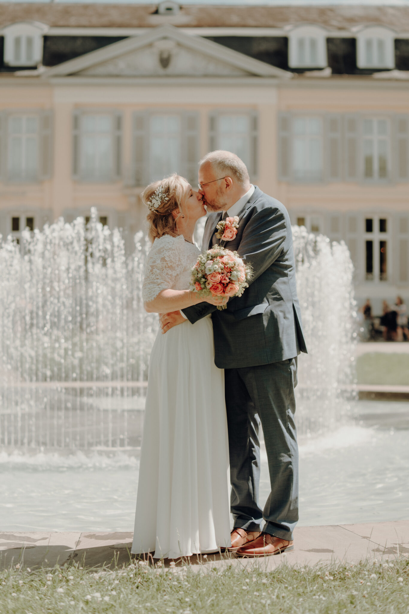 73R06114-231 Hochzeitskuss bei Hochzeitsfotoshooting vor Schloss