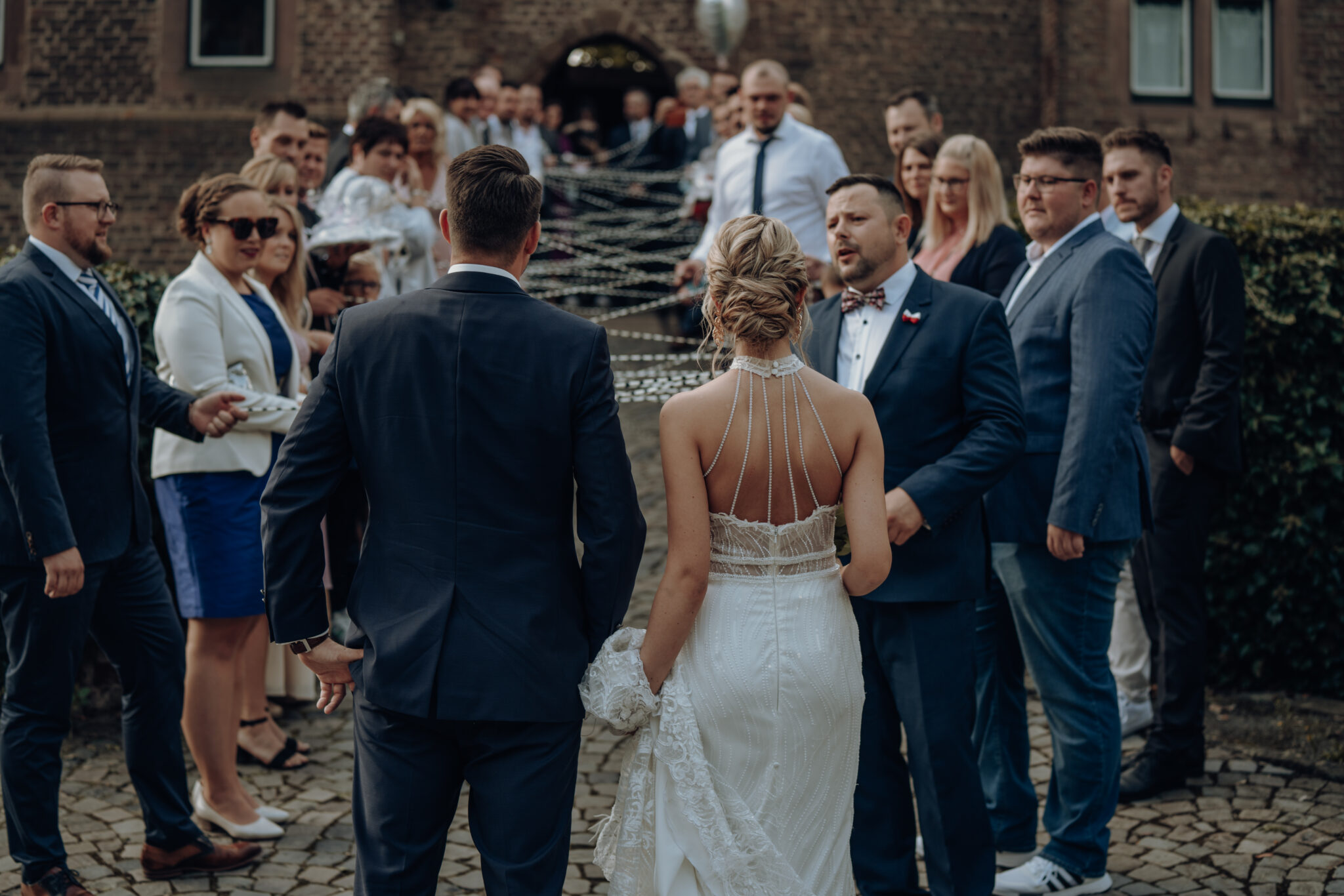 Fäden Fotos (3) Brautpaar geht durch Spalier in die Hochzeitslocation der Burg Konradsheim