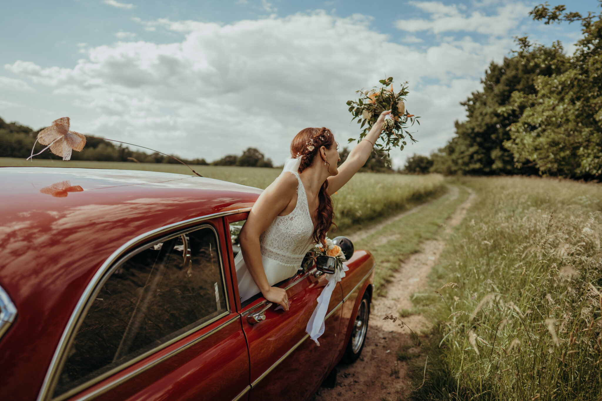 73R08077-2 Braut und roter Oldtimer auf dem Feld