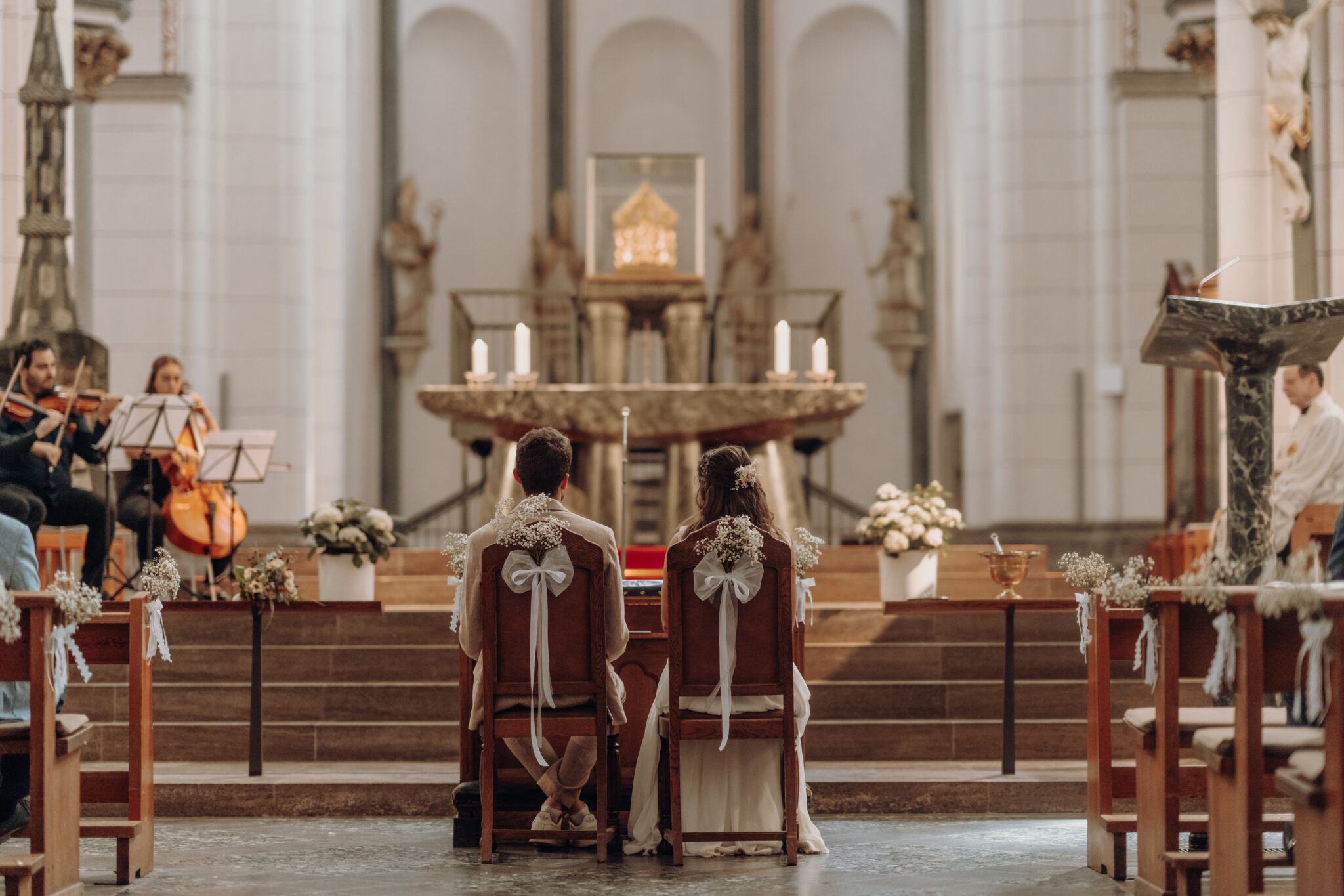 hochzeitas0822-2507-2 Kopie Brautpaar sitzt an Alter während kirchlicher Trauung