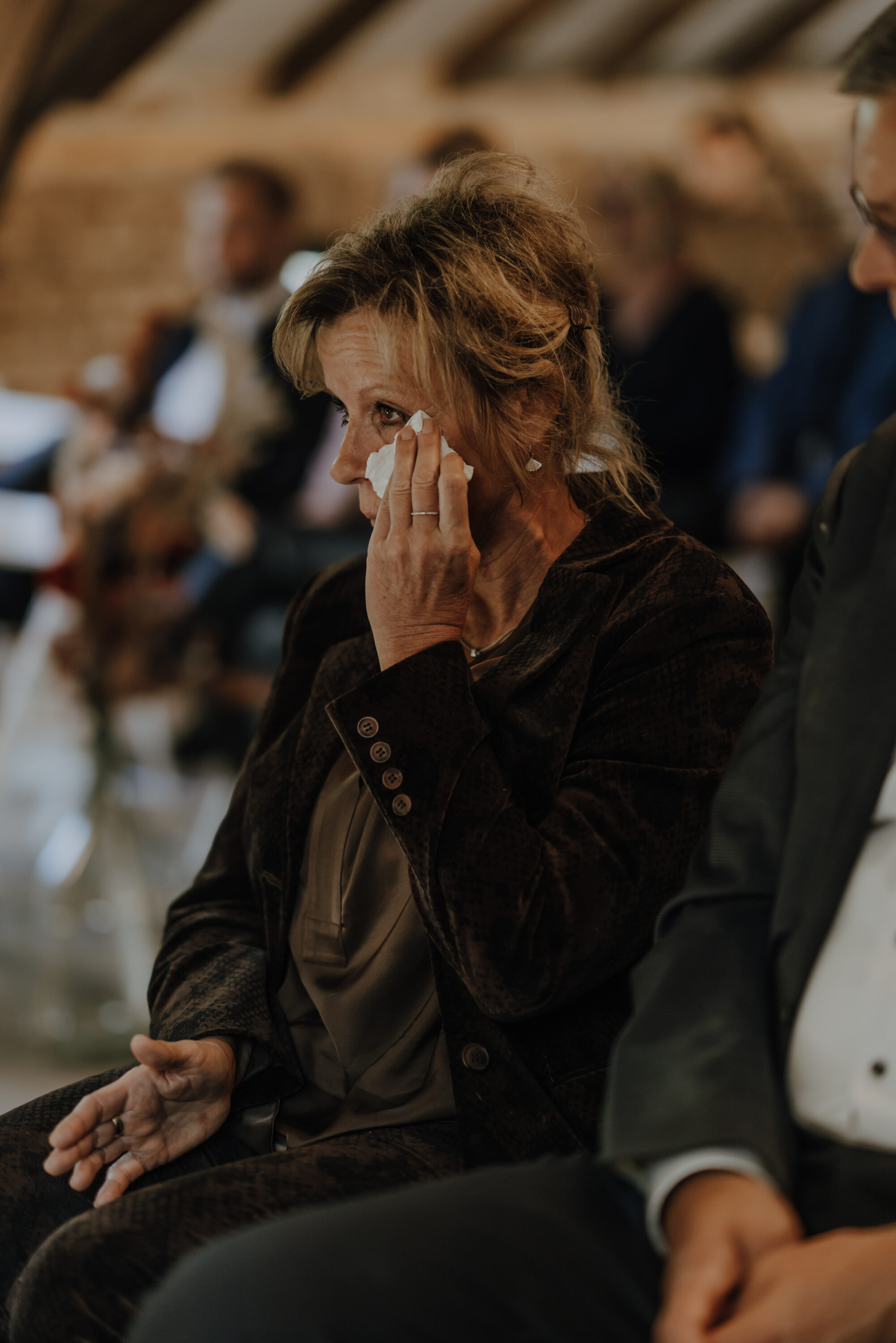 73R04978-annaundmarkhochzeit-3 Weinender weiblicher Gast wischt sich gerührt Tränen mit Taschentuch weg