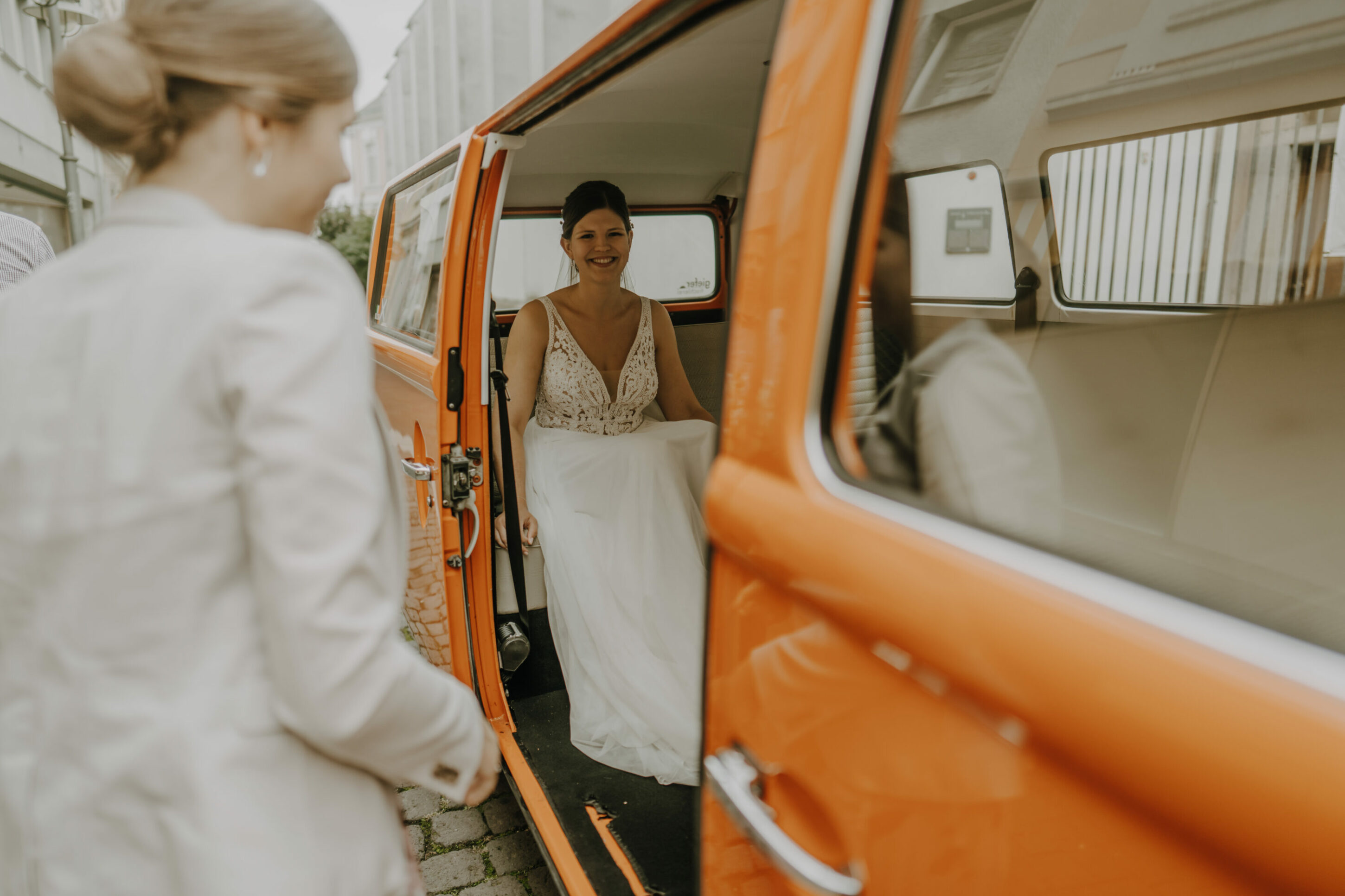 _74R4733-Inaundniklaskirchlich Braut sitzt in Oldtimer VW Bulli, glücklich