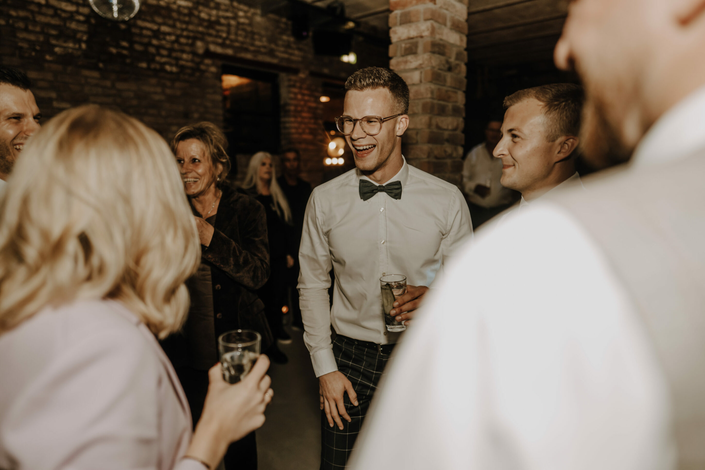 _74R7173-annaundmarkhochzeit-2 feiernde Gäste mit Getränken