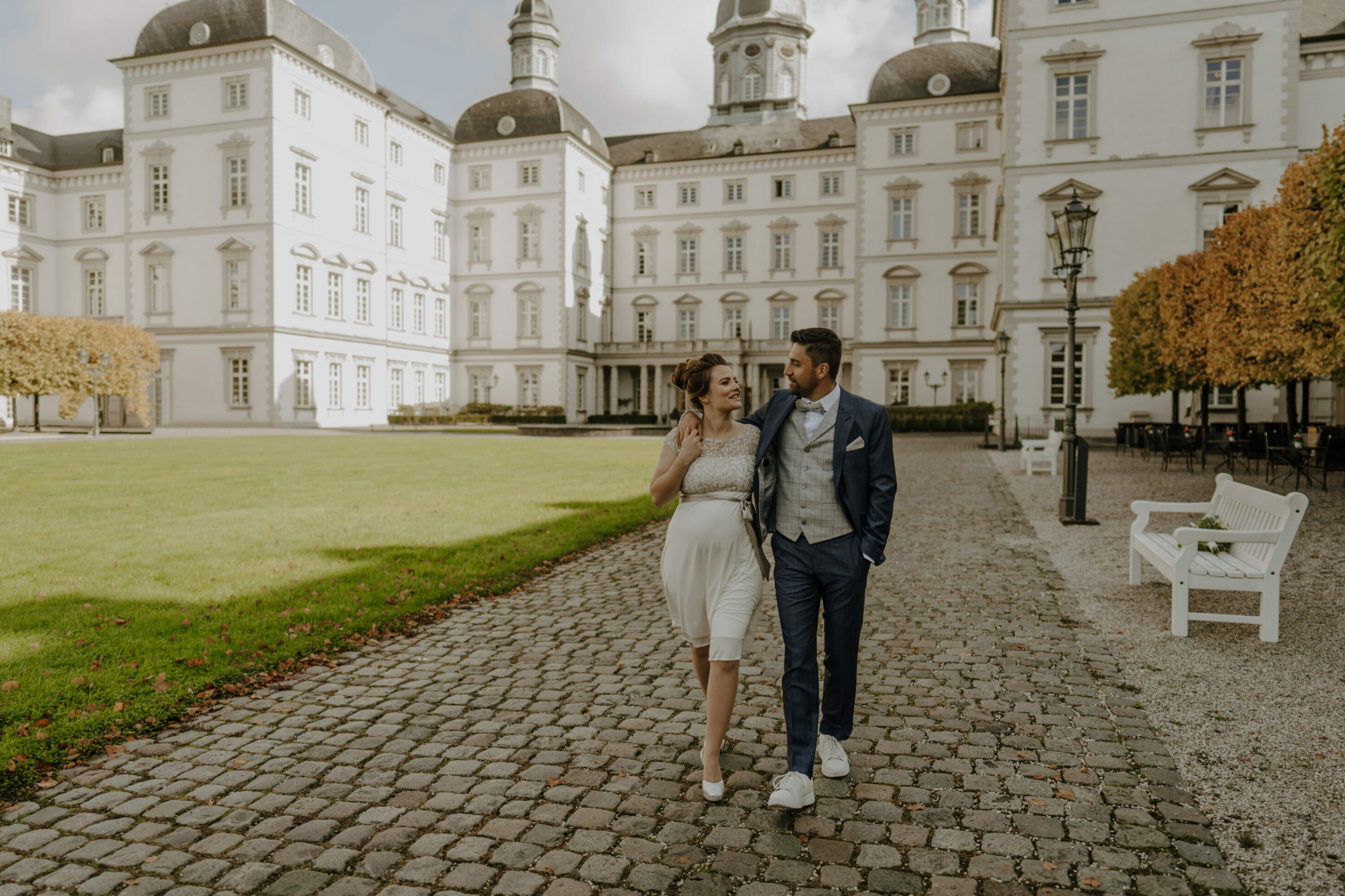 _74R7279-jessicaundmobinstandesamt Hochzeitspaar gemeinsamer Spaziergang durch Schlosspark, schauen einander an