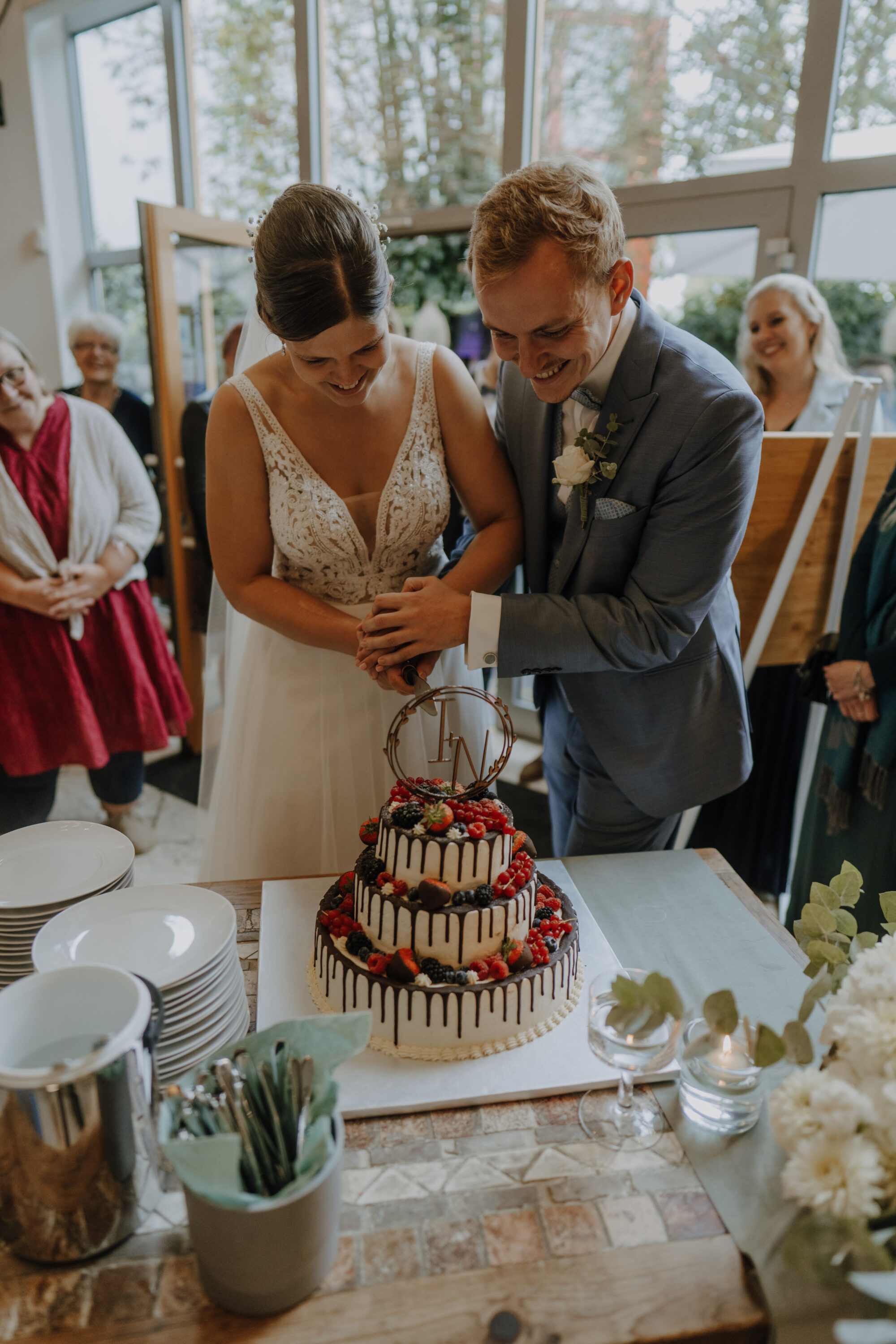 _74R9851-Inaundniklaskirchlich fröhliche Stimmung bei Brautpaar beim Anschnitt der Hochzeitstorte