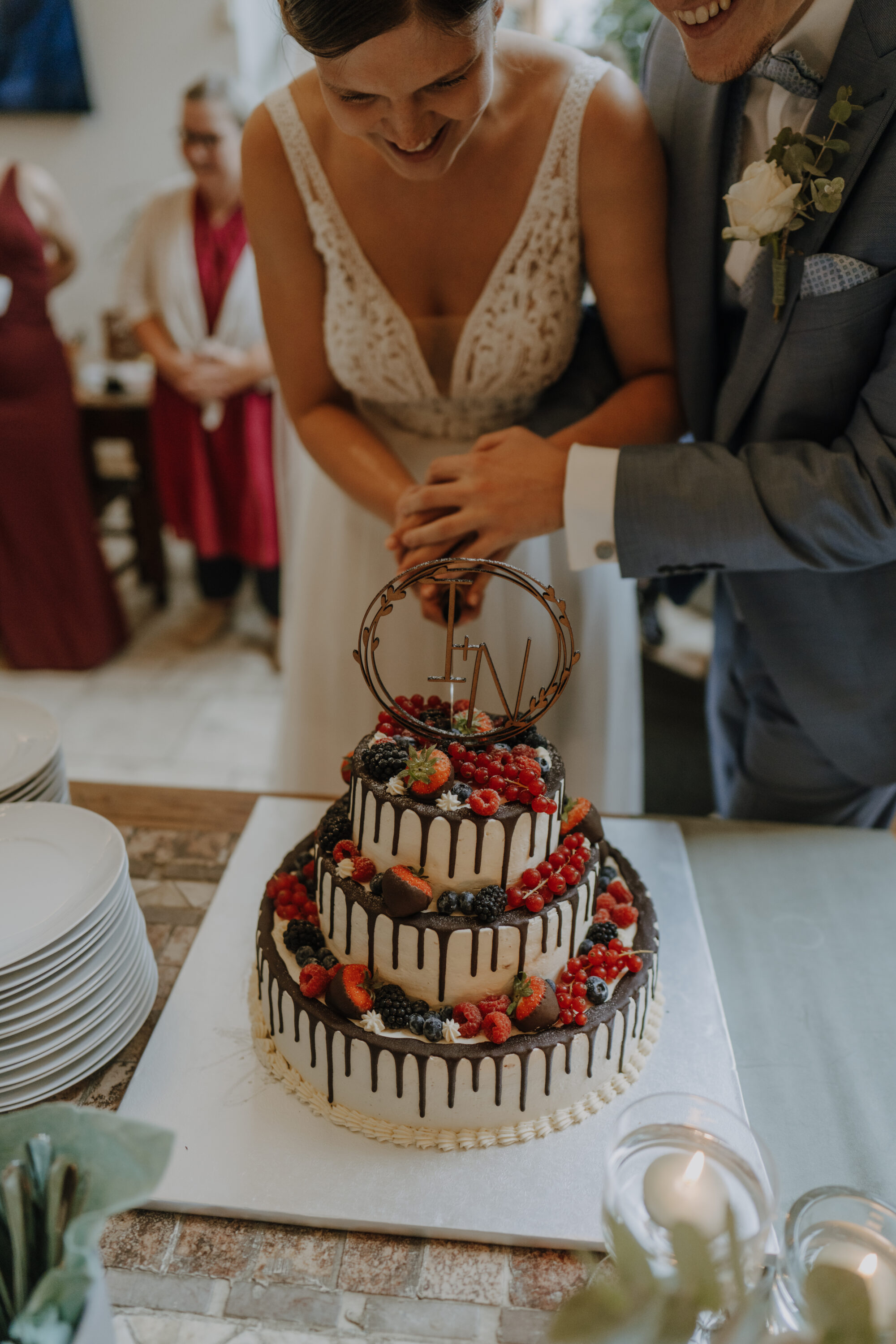 _74R9874-Inaundniklaskirchlich Die Hochzeitstorte wird vom Brautpaar angeschnitten, alle freuen sich