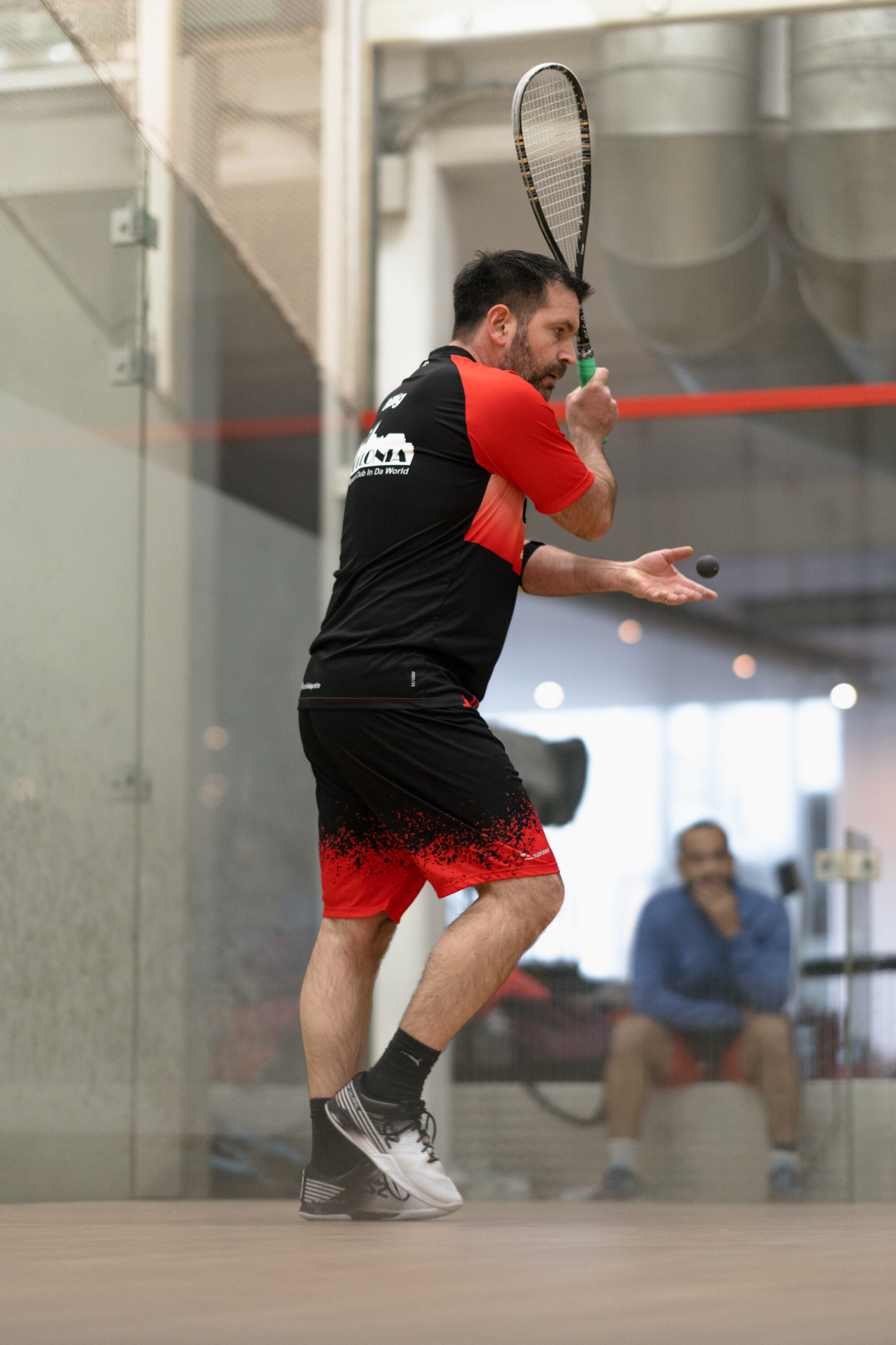 _74R9477-sccolonia Mann macht einen Aufschlag bei einem Squashspiel