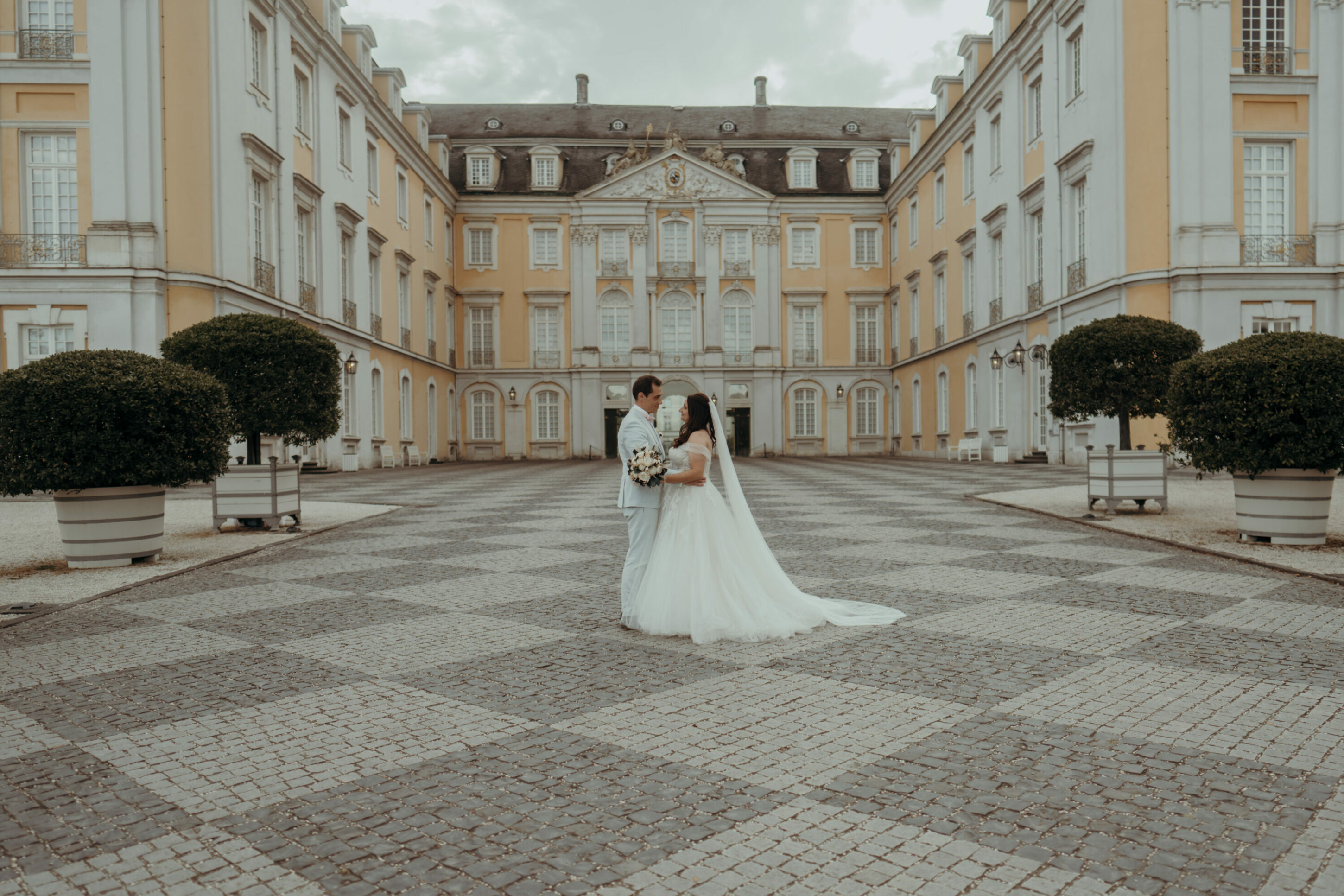 chrissandraafterwedding-5995-2 Kopie Brautpaar schaut sich tief in die Augen vor Schloss Augustusburg Haupteingang