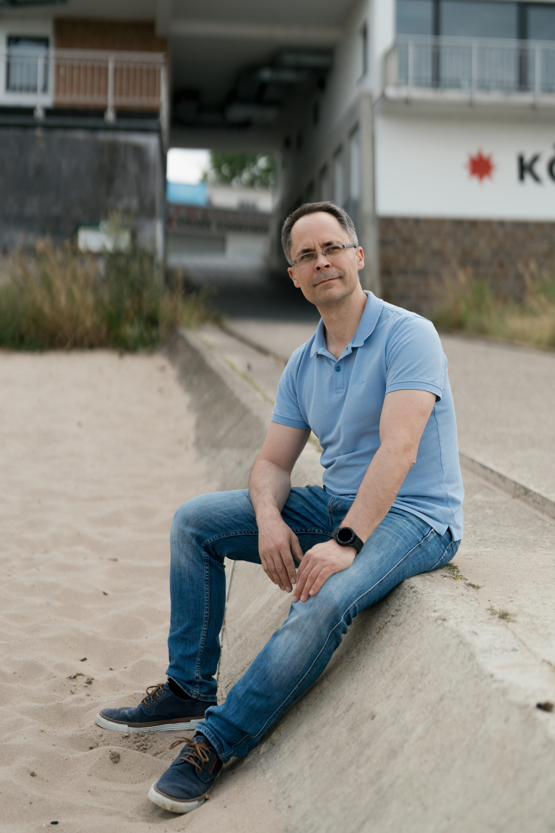 _4R17371-ma_sc_portrait_072023 Mann sitzt draußen und guckt in die Ferne